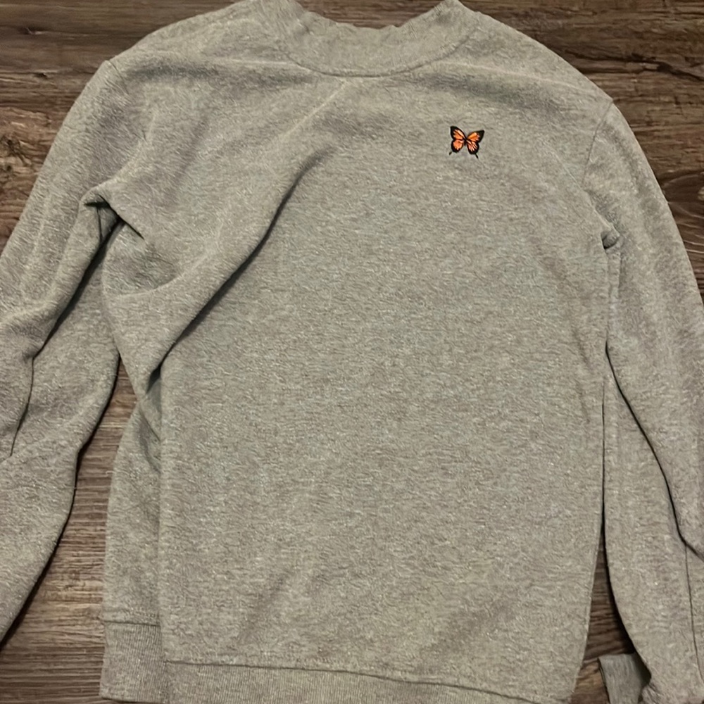 Grey crew neck with butterfly on it